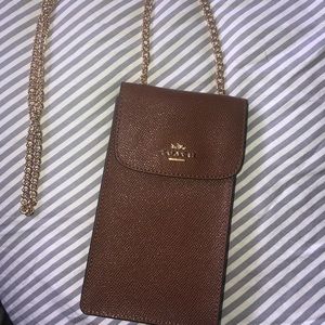 Coach wristlet crossbody. Brown bag with a gold chain.